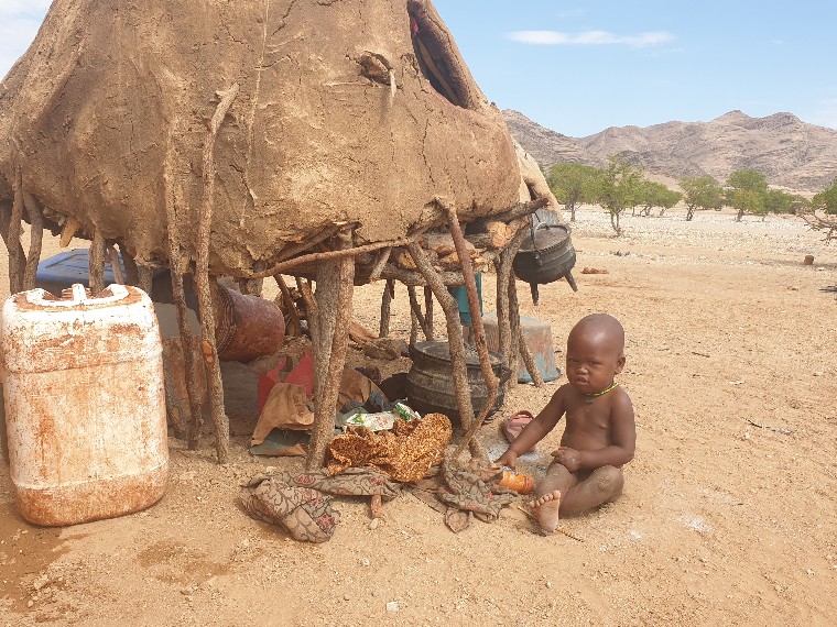 Un autre bébé Himba jouant prés de la cuisine familiale, Désert du Namib, Province de Kunene, Namibie.